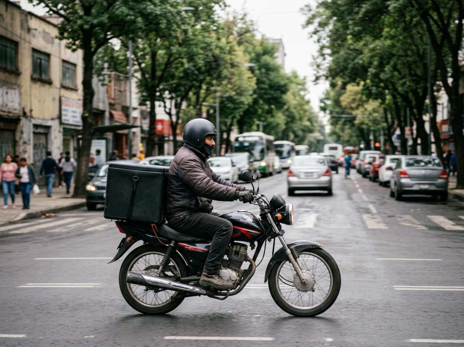 Un repartidor en motocicleta con caja de entregas en Ciudad de México